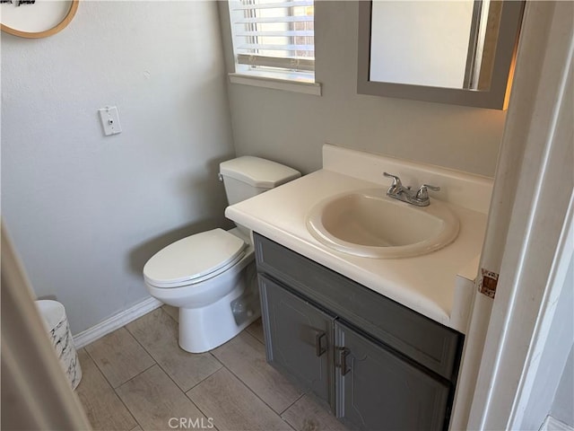 500 Sherri Way, Turlock, CA 95382 - half bathroom with vanity, toilet, baseboards, and wood finished floors