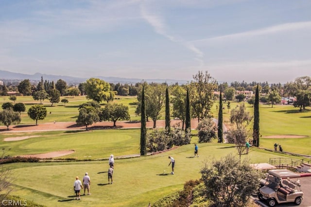 view of property's community with golf course view and a lawn