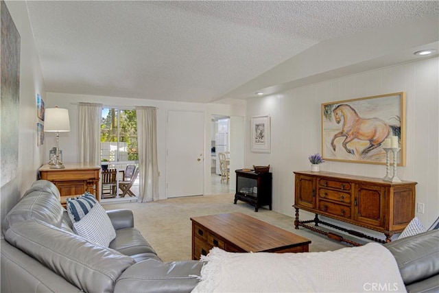carpeted living area with lofted ceiling and a textured ceiling