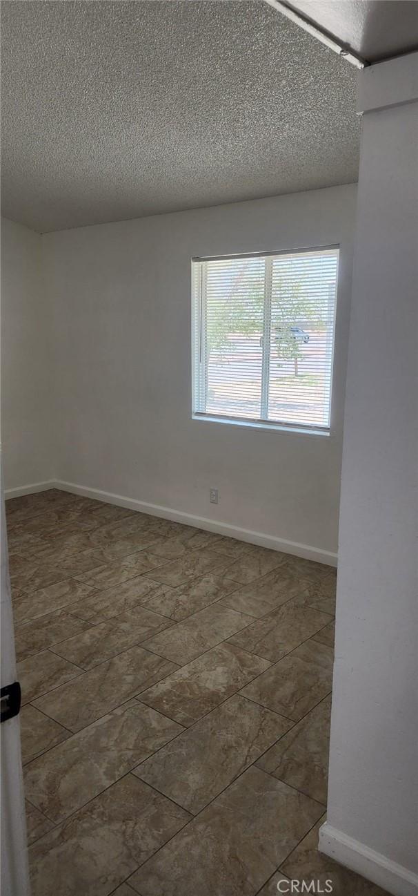 empty room featuring baseboards and a textured ceiling