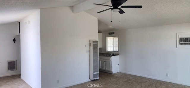 unfurnished room featuring a textured ceiling, a ceiling fan, visible vents, a heating unit, and baseboards