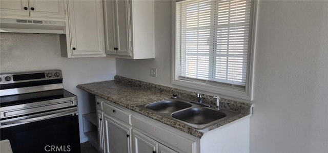 kitchen with light countertops, electric range, white cabinets, under cabinet range hood, and a sink