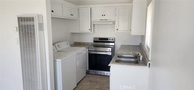 washroom featuring laundry area, a heating unit, a sink, and washing machine and dryer