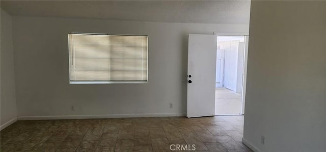 spare room with baseboards