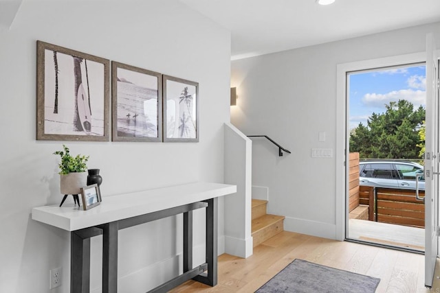 entryway featuring light wood-type flooring, stairs, baseboards, and recessed lighting