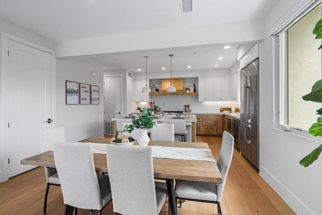 dining space featuring light wood-type flooring, recessed lighting, wine cooler, and baseboards