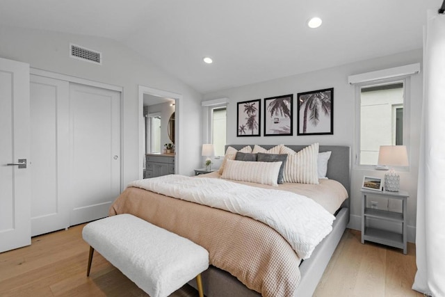 bedroom with lofted ceiling, light wood-style flooring, a closet, ensuite bath, and recessed lighting