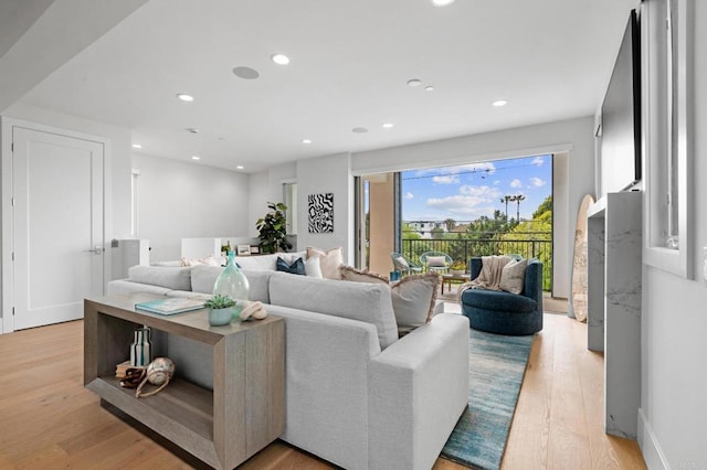 living area with light wood-style floors and recessed lighting