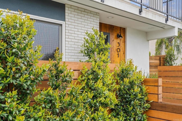 view of exterior entry with brick siding and stucco siding