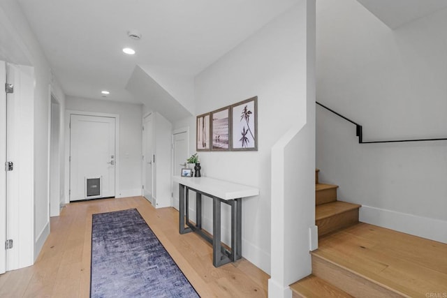 foyer entrance featuring light wood finished floors, stairway, recessed lighting, and baseboards