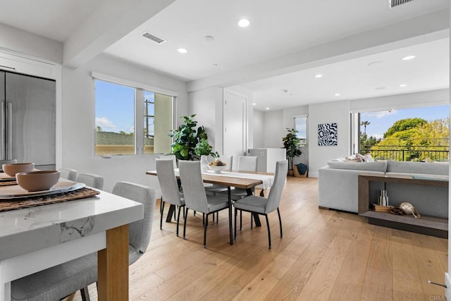 dining space featuring light wood-type flooring, healthy amount of natural light, and recessed lighting