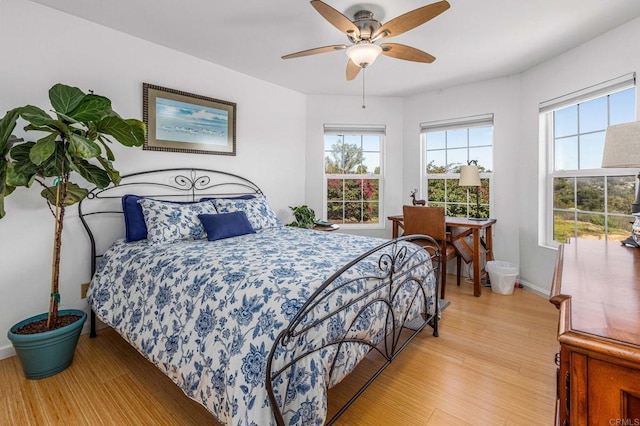 bedroom featuring light wood-style floors, baseboards, and a ceiling fan