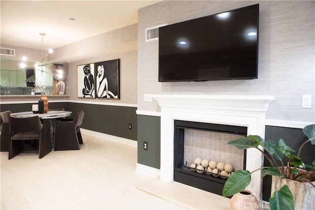 living area featuring baseboards, visible vents, and a fireplace with raised hearth