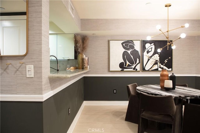 dining area with a chandelier, visible vents, and baseboards
