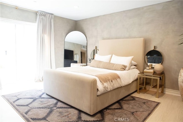 bedroom featuring wood finished floors and visible vents