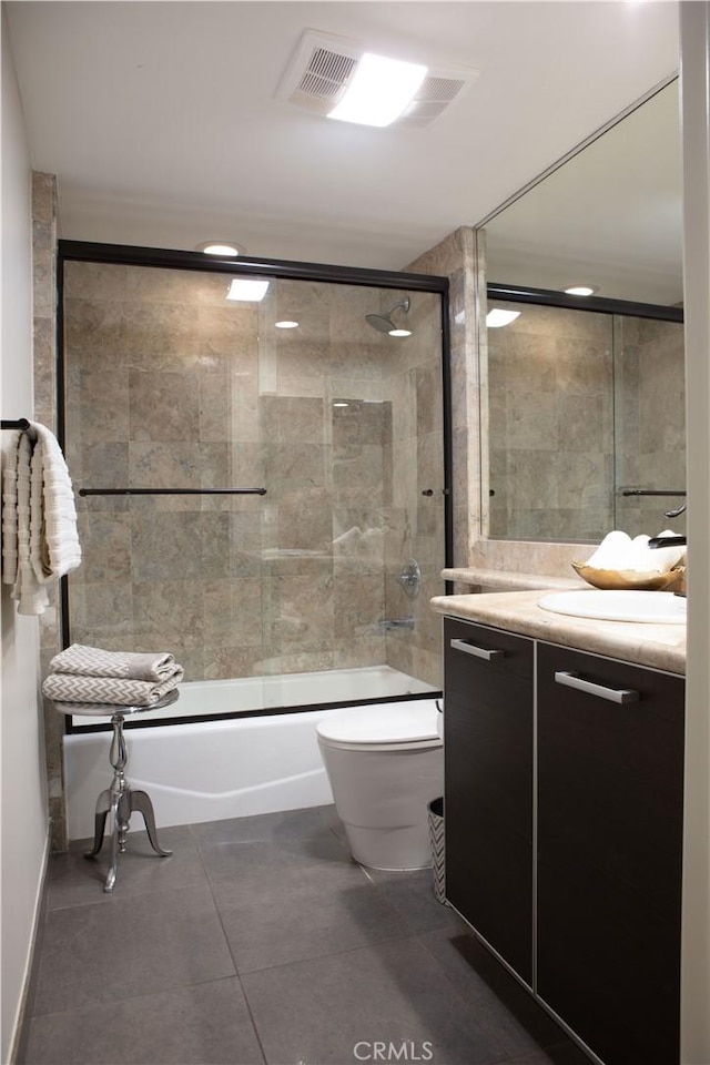 full bathroom featuring tile patterned floors, vanity, shower / bath combination with glass door, and toilet