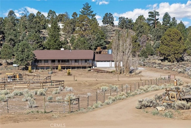 view of yard featuring a garage, fence, and driveway