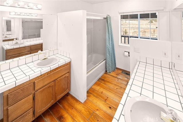 full bathroom with wood-type flooring, shower / tub combo, vanity, and baseboards