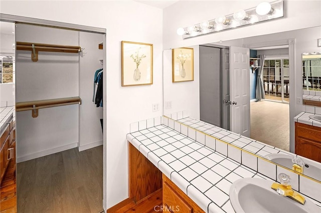 bathroom featuring wood finished floors, vanity, and baseboards