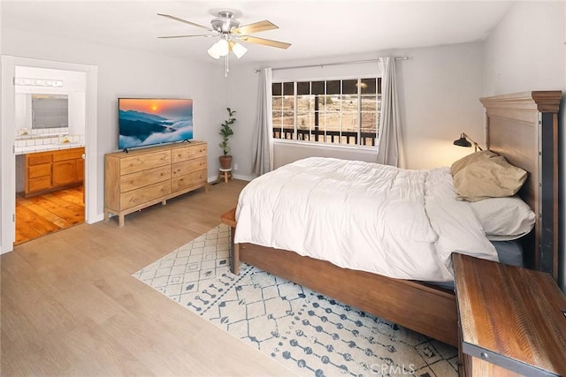 bedroom featuring connected bathroom, light wood-type flooring, and a ceiling fan