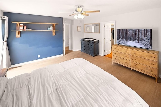 bedroom featuring baseboards, visible vents, wood finished floors, and ceiling fan