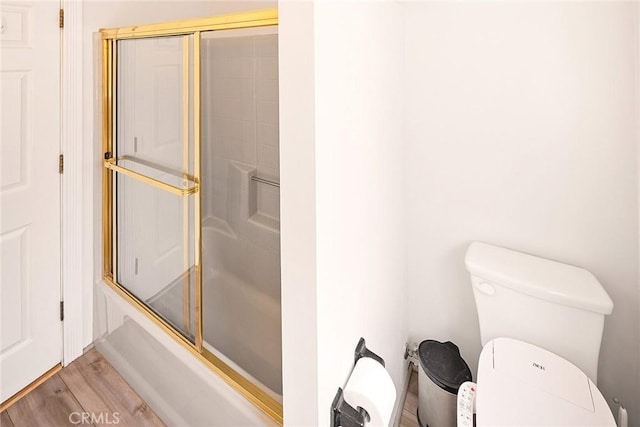 bathroom with shower / bath combination with glass door, toilet, and wood finished floors