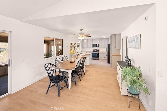 dining area with baseboards, light wood finished floors, and plenty of natural light