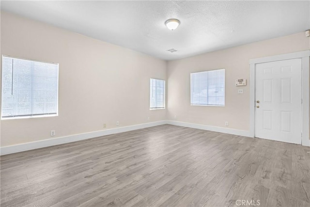 1335 N Lugo Ave, San Bernardino, CA 92404 - unfurnished room featuring a textured ceiling, wood finished floors, and baseboards