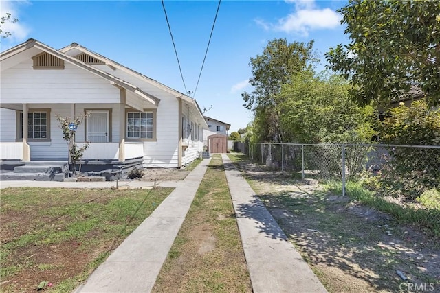 1335 N Lugo Ave, San Bernardino, CA 92404 - bungalow-style house with a porch, a storage shed, an outbuilding, and fence