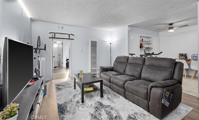 2501 W Redondo Beach Blvd Unit 217, Gardena, CA 90249 - living area with a ceiling fan, a heating unit, wood finished floors, and a textured ceiling