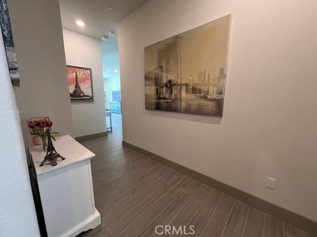corridor with baseboards and dark wood-style floors
