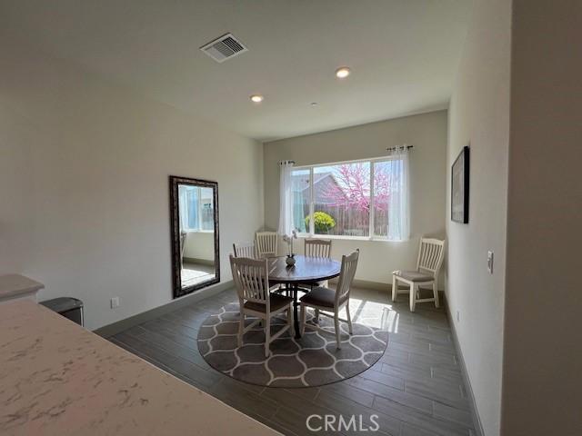 dining area featuring dark wood-type flooring, baseboards, visible vents, and recessed lighting