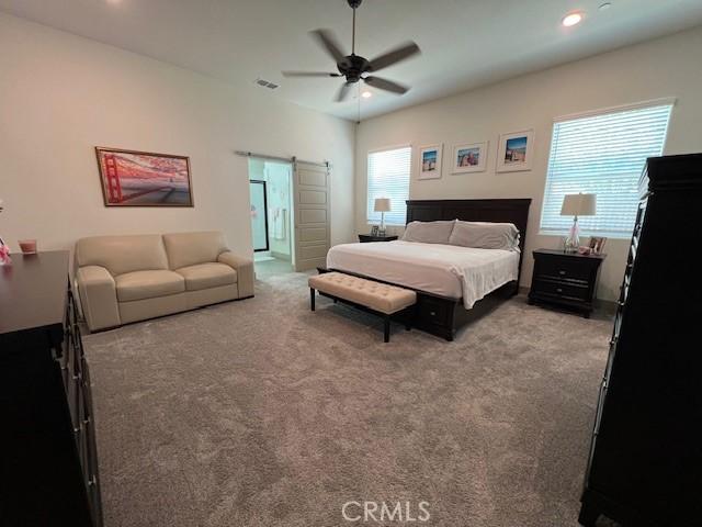 bedroom with a ceiling fan, visible vents, recessed lighting, a barn door, and carpet flooring