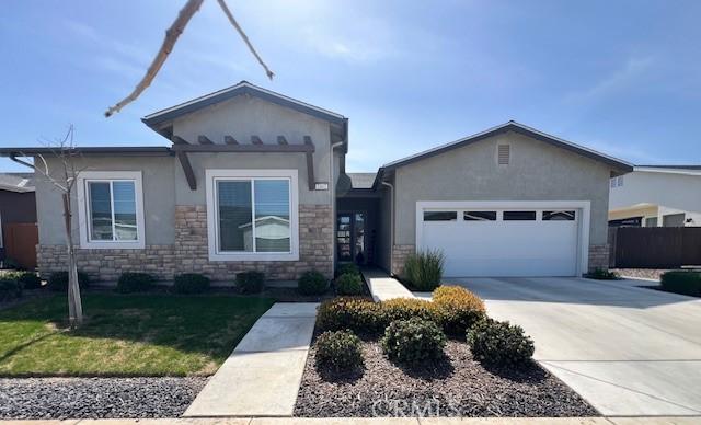 ranch-style home with stucco siding, driveway, stone siding, a front yard, and a garage
