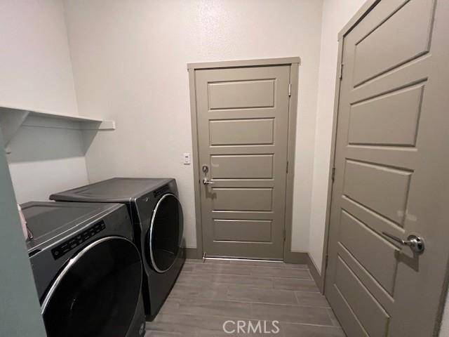 washroom with baseboards, washing machine and dryer, and laundry area