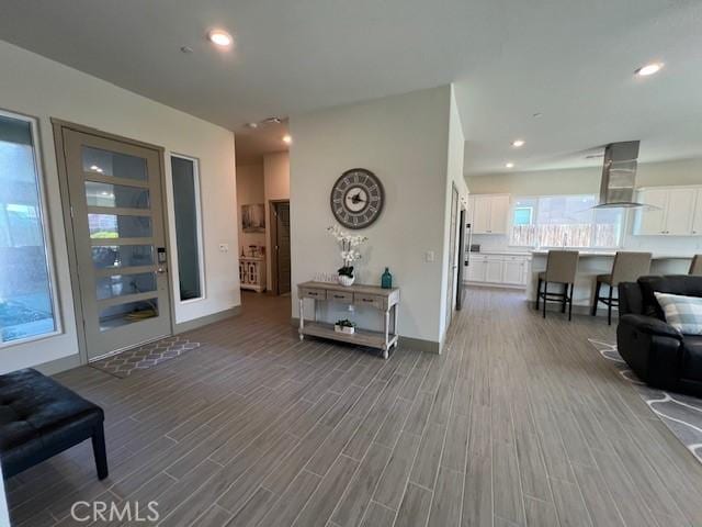 living area with wood finished floors, baseboards, and recessed lighting