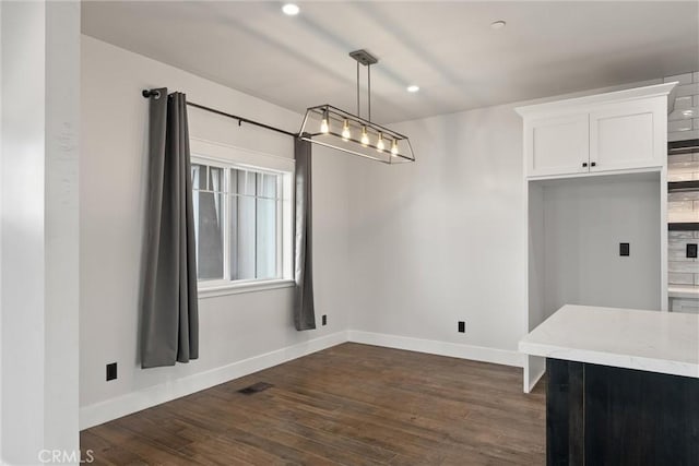 unfurnished dining area with dark wood-type flooring, visible vents, baseboards, and recessed lighting