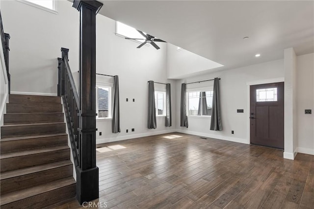 foyer entrance with dark wood finished floors, baseboards, stairs, and ceiling fan