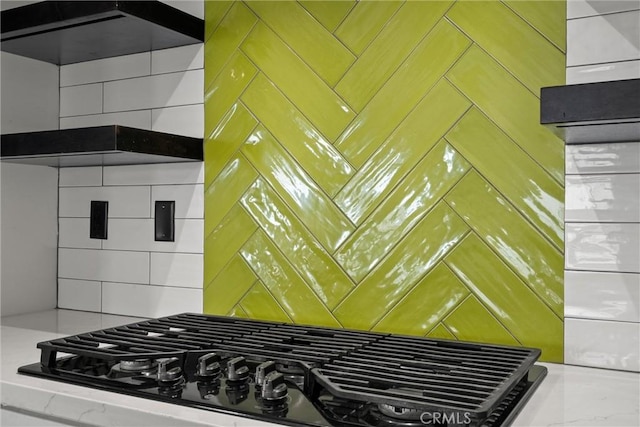 kitchen with black gas stovetop and decorative backsplash