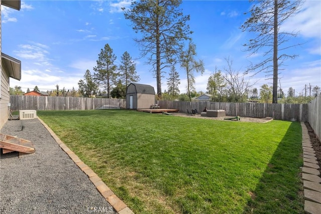 view of yard with a storage shed, a fenced backyard, an outdoor hangout area, and an outbuilding