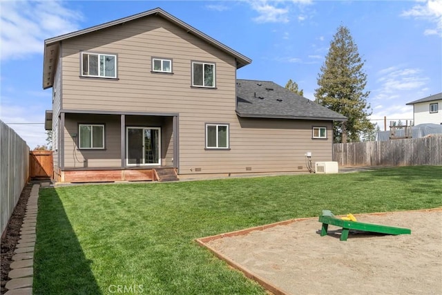 rear view of house featuring a yard and a fenced backyard