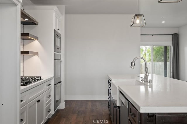 kitchen with black microwave, gas stovetop, white cabinetry, dark wood-style flooring, and baseboards