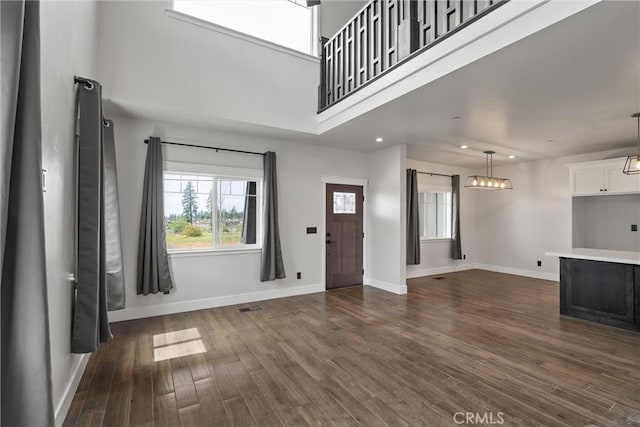 foyer with baseboards, dark wood-style floors, and plenty of natural light