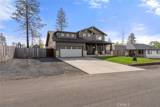 craftsman-style house featuring stone siding, fence, a front lawn, an attached garage, and driveway