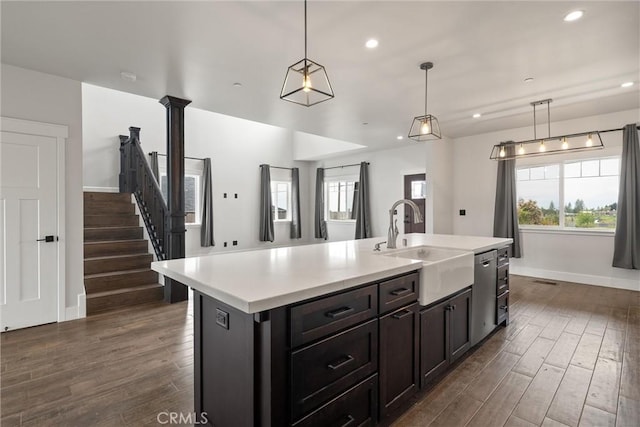 kitchen featuring baseboards, dark wood-style floors, light countertops, and a sink