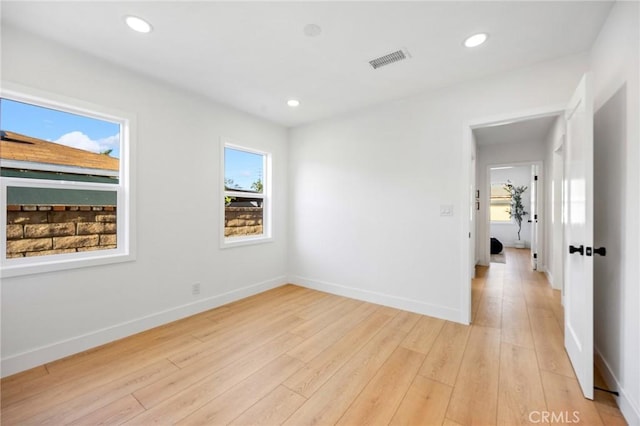 unfurnished room featuring recessed lighting, light wood finished floors, visible vents, and baseboards