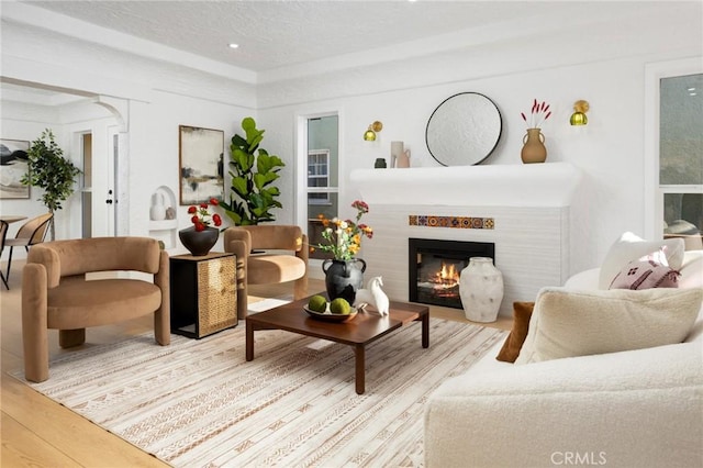 living area with wood finished floors and a glass covered fireplace