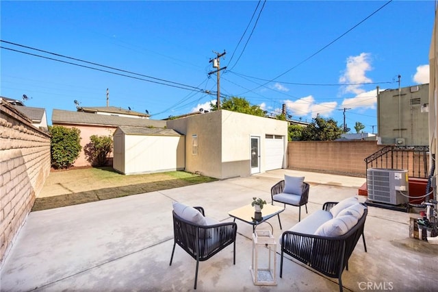 view of patio featuring an outbuilding, central air condition unit, outdoor lounge area, a fenced backyard, and concrete driveway