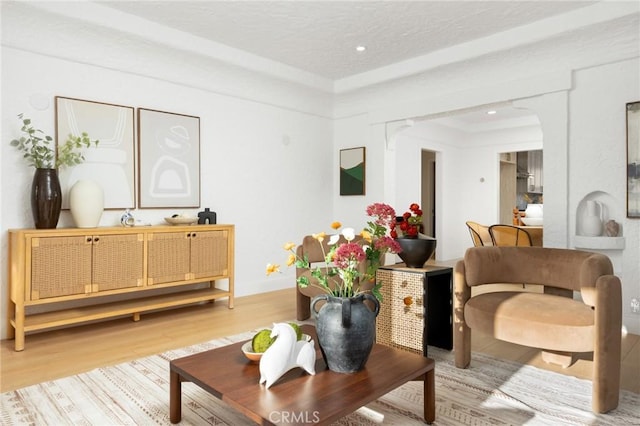 sitting room featuring recessed lighting, arched walkways, and light wood-type flooring