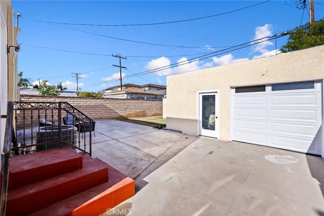 view of patio / terrace with an outbuilding, a garage, and fence